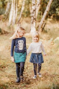 two little girls walking in woods