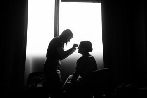 Silhouette of bride getting make up done