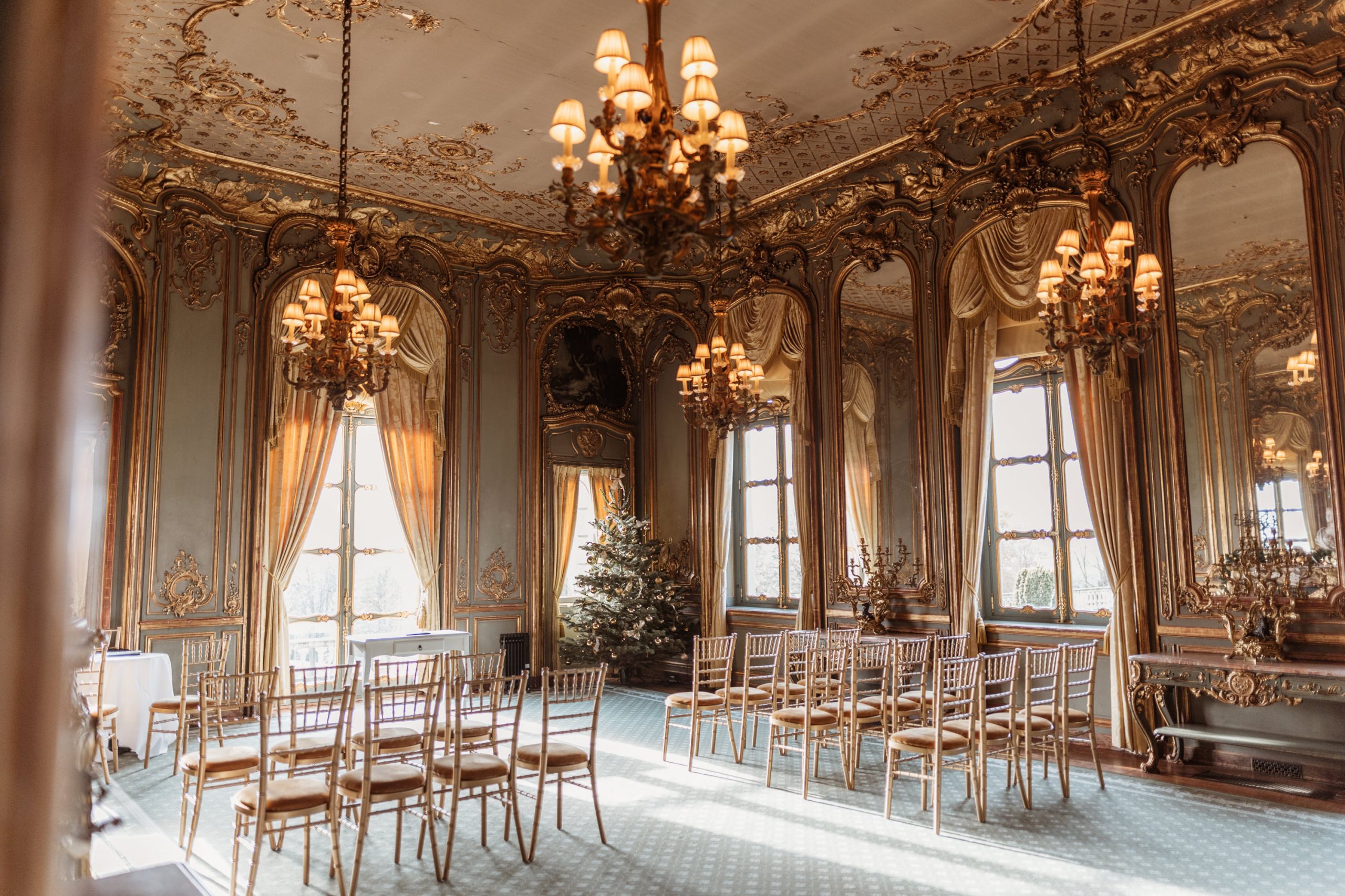 Ceremony room at Cliveden House, grand interior with lots of gold decor and chairs and chandeliers