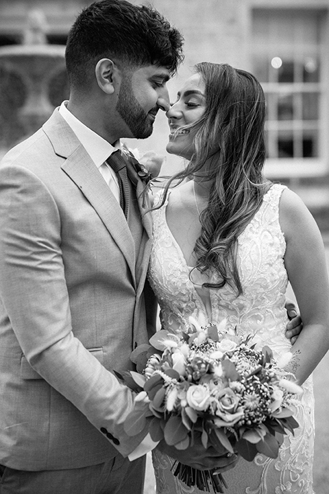 black and white image of Indian bride and groom smiling at each other with noses just touching